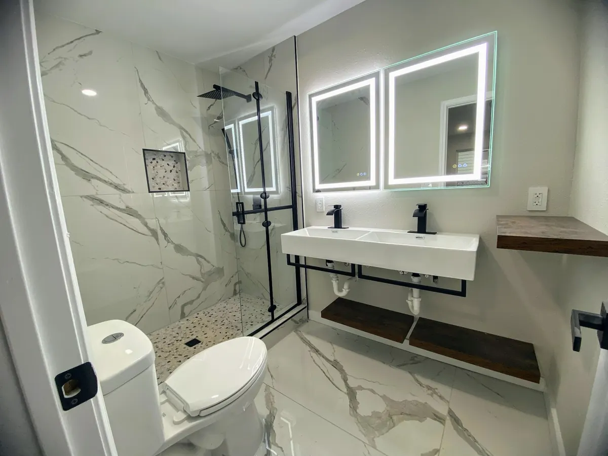 Finished bathroom with a walk-in shower, double vanity and illuminated mirrors