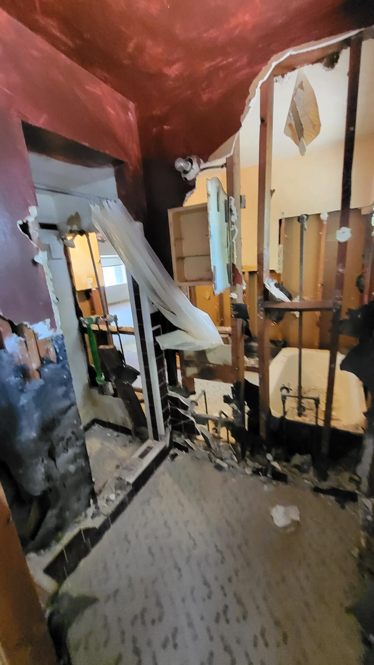 Bathroom during renovation with exposed framing around the window and original fixtures